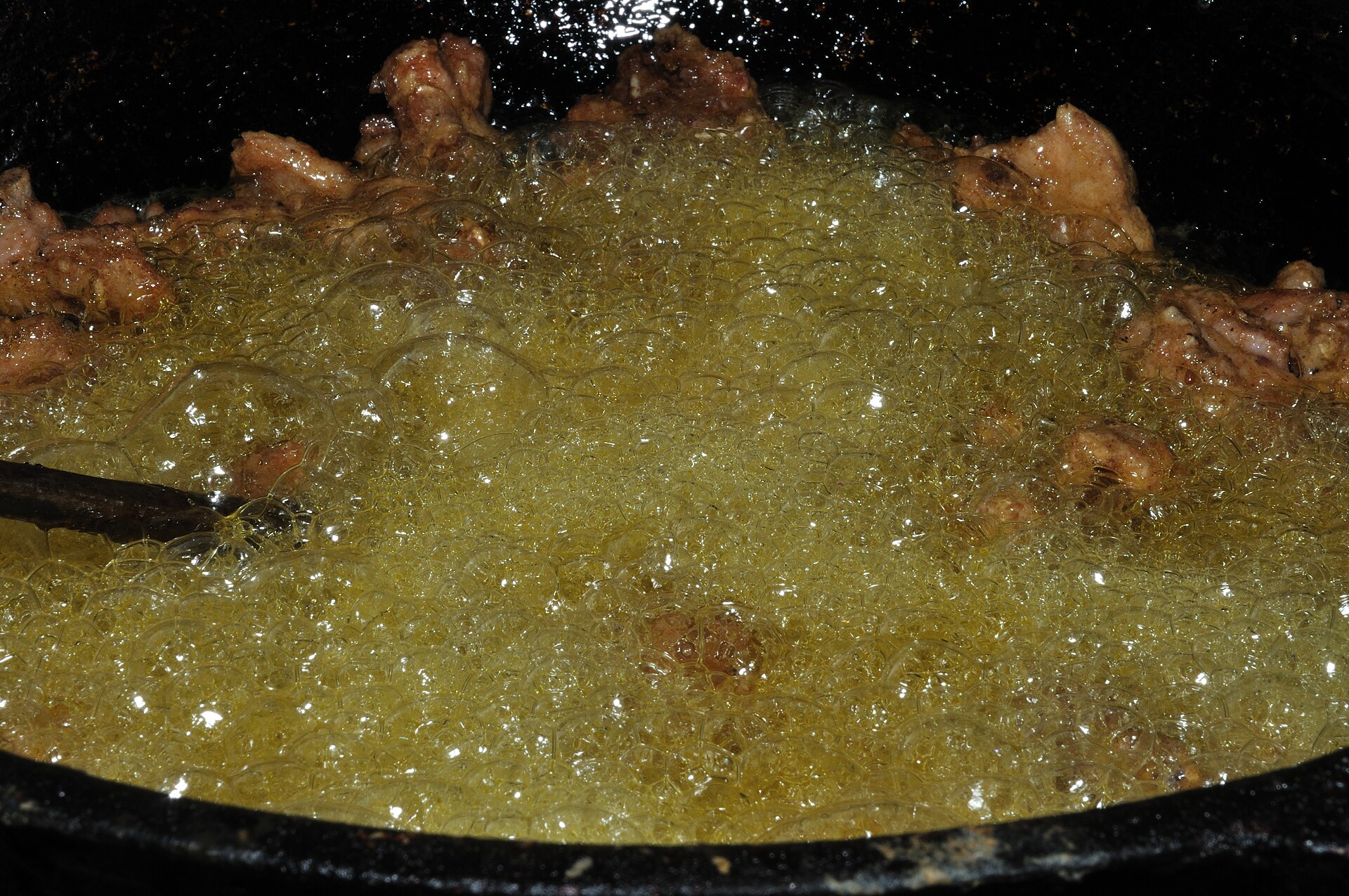 Chicken bubbling in a pot of hot oil